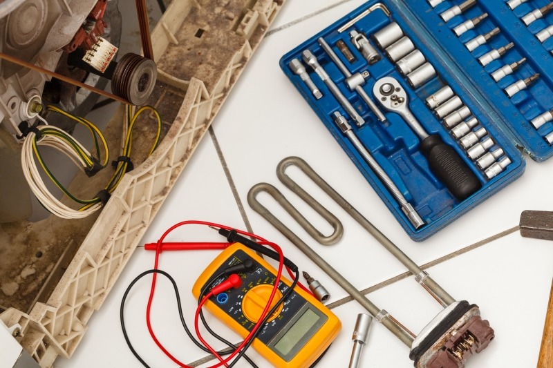 Engineer repairing a washing machine in Enfield