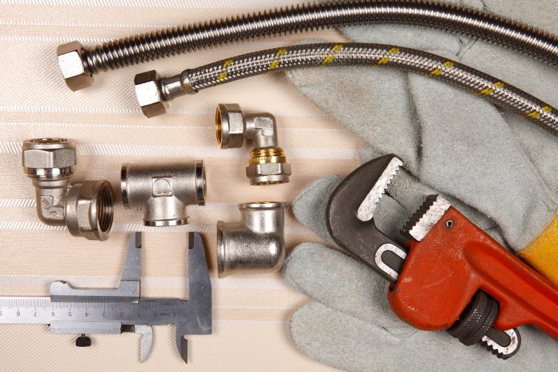 Plumber working on pipes in a Enfield home